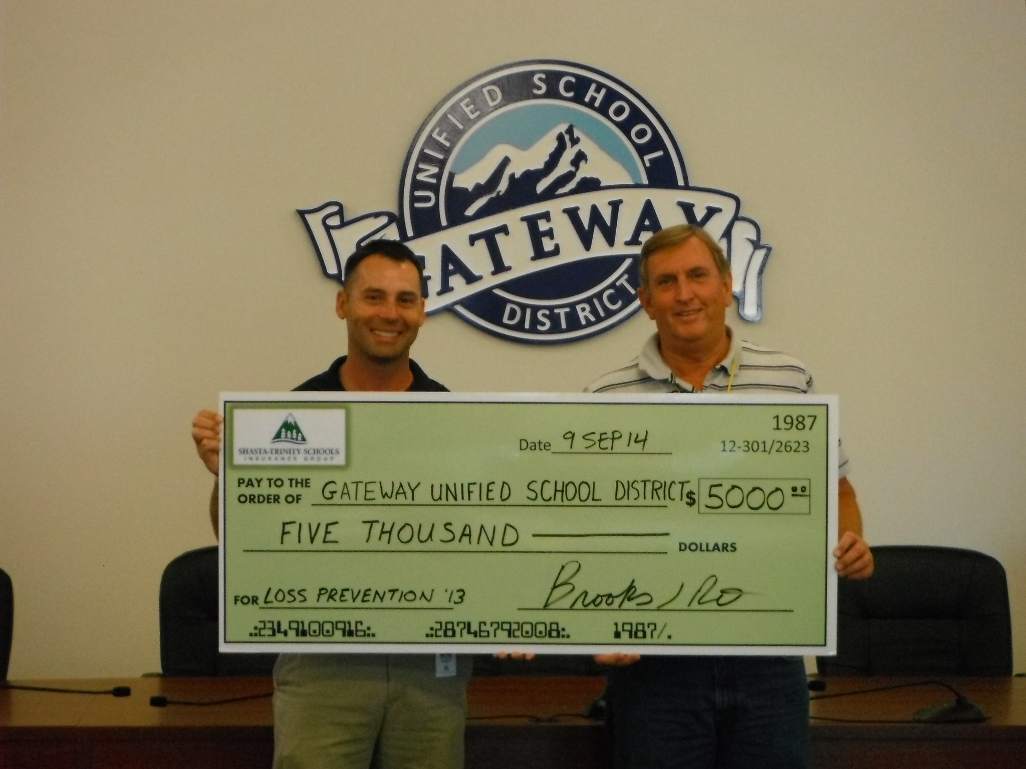 Employee of Gateway Unified School District being presented with large check